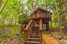 a tree house in the woods with stairs leading up to it