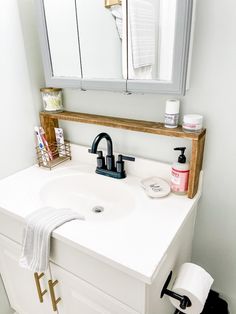 a white bathroom sink sitting under a mirror