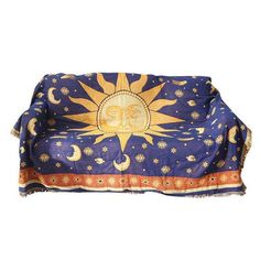 a sun and moon design on a blue couch cover with fringes around the edges