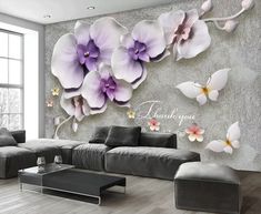 a living room with flowers on the wall and a large couch in front of it