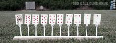 several white and red playing cards are placed in the grass