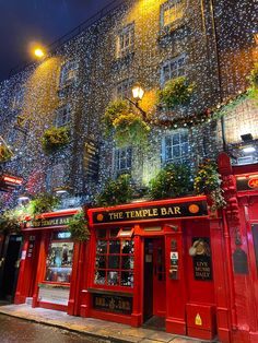 the temple bar is lit up at night with christmas lights on it's windows