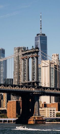 a boat is going under the brooklyn bridge