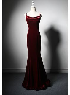 Arranged with meticulous attention to detail, this stunning prom dress captures the essence of classic glamour and modern sophistication. The luxurious burgundy velvet fabric not only looks exquisite but also feels incredibly soft and comfortable against the skin. The dress features a flattering silhouette that hugs your curves, while the draped neckline and slim spaghetti straps add a touch of delicate femininity. The floor-length design creates a striking, elegant look that is perfect for any formal event. The rich color and sumptuous texture of the velvet ensure you stand out with confidence and grace. Ideal for proms, formal dances, or any event where you wish to leave a lasting impression, this dress is designed to make you feel like the belle of the ball. Complete your ensemble with Long Red Elegant Dresses, Deep Red Evening Gown, Prom Dresses Red Velvet, Velvet Dark Red Dress, Red Velvet Evening Dress, Designer Evening Gowns Classy, Dark Red Hoco Dress Long, Dark Red Mermaid Dress, Wine Red Velvet Dress