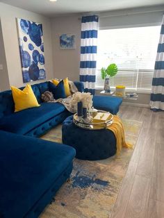 a living room with blue couches and yellow pillows on top of it's rug