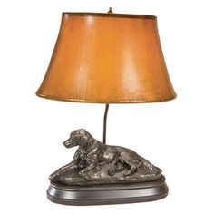 a lamp with a dog sitting on it's side next to a light shade