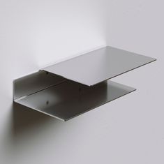 a white wall mounted shelf on the side of a wall