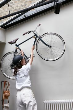 a woman is fixing a bicycle on the wall