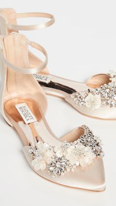 a pair of women's shoes with flowers and pearls on the heel, all in satin fabric