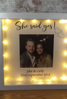 a lighted photo frame with lights around it and the words she said yes on it