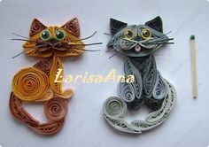 two cats made out of paper and one has a pencil