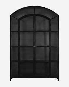 a black bookcase with glass doors on the top and bottom shelves, in front of a white background