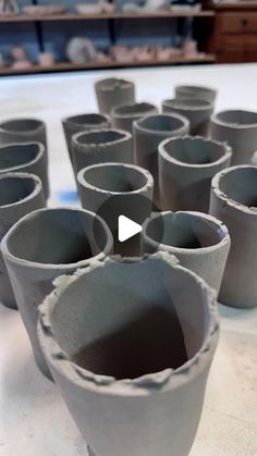 several gray cups sitting on top of a table next to each other with holes in them