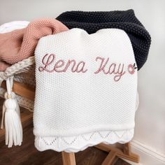 a white blanket with the word lena way written on it next to other blankets