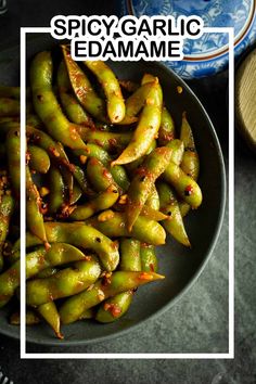 green beans in a bowl next to a blue and white vase on a table top