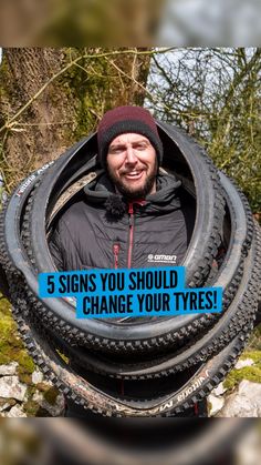 a man standing in front of a pile of tires with the words 5 signs you should change your tires