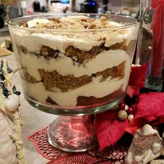 a glass dish filled with food on top of a table next to christmas decorations and candles