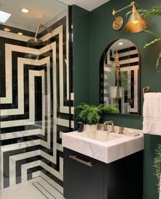 a bathroom with green walls and black and white tiles on the floor, along with a marble sink