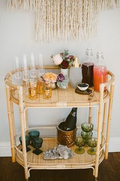 a bar cart with drinks and glasses on it