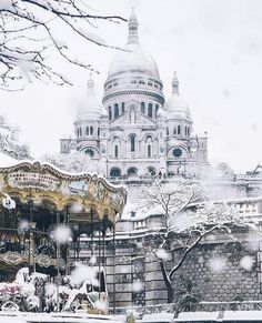 a merry go round in front of a building with snow on the ground and trees