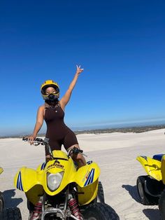 a woman riding on the back of a yellow four wheeler