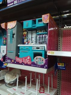 a toy kitchen with blue cabinets and pink walls in a store display area for children's toys