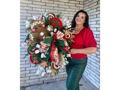 a woman is holding a christmas wreath with gingerbreads and candy canes on it