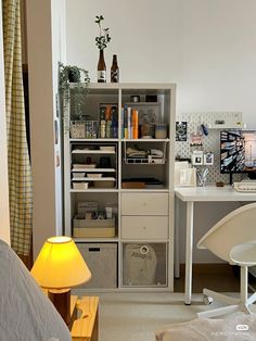 a room with a bed, desk and shelves filled with items on it's sides