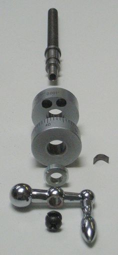 an image of a machine tool on a white surface with screws and wrench