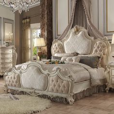 an ornate bedroom with white furniture and chandelier