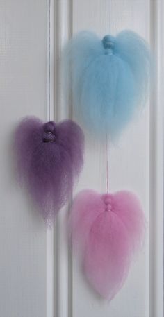 two heart shaped pom poms hanging from the side of a door