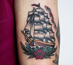 a woman's arm with a ship tattoo on it