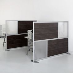 an office cubicle with two desks and one chair in front of the wall