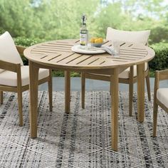 an outdoor table with four chairs and a bottle of beer on top of the table