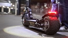 a close up of a motorcycle on the ground with its brake lights on and it's rear wheel