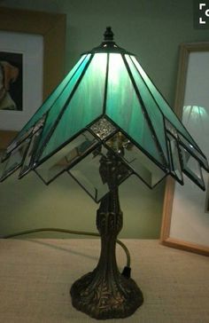 a lamp that is sitting on top of a table next to some pictures and frames