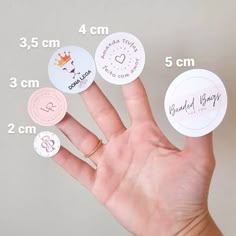 a person's hand with four different types of stickers on it and the size of their fingers