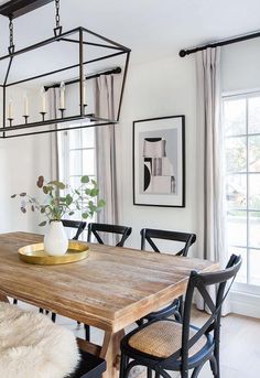 a dining room table with chairs and a vase on it