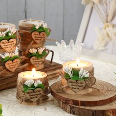 candles with flowers and hearts on them sitting on wood slices in front of other decorations