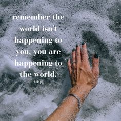 a person's hand reaching out to the water with a quote on it that says, remember the world isn't happening