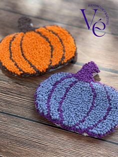 two crocheted pumpkins sitting on top of a wooden table