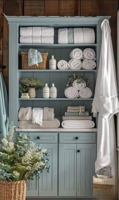 a blue cabinet filled with lots of white towels and other items on top of it