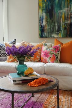 a living room filled with furniture and colorful pillows