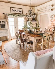 a dining room table with chairs and a christmas tree in the center surrounded by wreaths