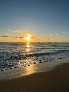 the sun is setting over the water at the beach