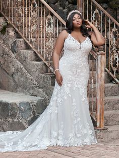 a woman standing in front of stairs wearing a wedding dress