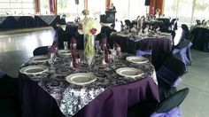 the tables are set with purple and black linens