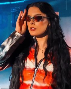 a woman with long black hair wearing sunglasses