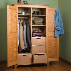 an open wooden closet with clothes hanging on it