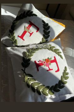 two embroidered pillows on top of each other